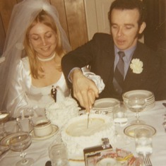 Cutting their wedding day cake!