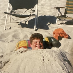 Johnny would let his friends bury him in the sand every time we went to the bech