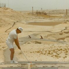 Golf at the Bahrain Golf Club, note the orange ball, tar lines that denote the fairway [outside play the ball where it is, inside pick up the ball, place it on a piece of AstroTurf that you carry around and play off that!] and the “browns”, oiled sand the