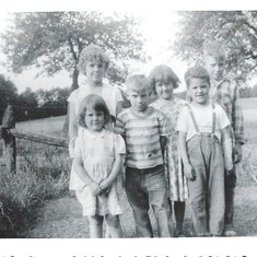 John in the stripped shirt with his 2 siblings and cousins