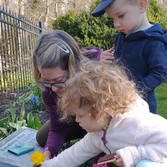 Bloom, Oliver, and Teresa planting flowers in Julian's garden
