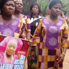 Uju holding a picture of Justina, Ify and Amaka during the burial rites for Justina