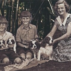 A young Katie with Geoff (then Jody), Revett, and four of the important things in her life (Tallulah and Clottie being the adult dogs, Mosie one of the pups)
