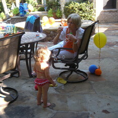 Grammy blowing bubbles for Mylie to play in. Mylie's second birthday in Coppell
