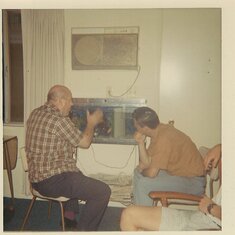 Kelly’s Grandpa Hal I and Dad Hal II studying fish tank 