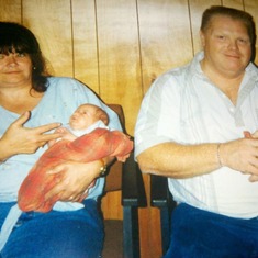 Mom is holding Caleb and Dad is holding Christian @ Dad's Barber Shop in Hebron KY
