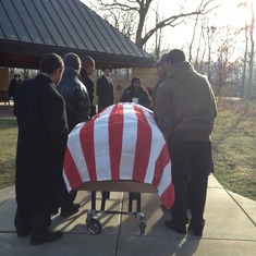 Pallbearers carry "J" to the shelter for military ceremony.