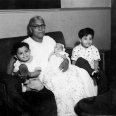 Khalid's birth (Daddy in the arms of Dr.Gosh who delivered him in Calcutta in August 1954) His older brother Shahid on right and cousin brother Mac on his left.