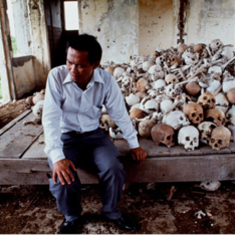 Dith Pran seated in front of the skulls of people victimized by the Cambodian Genocide