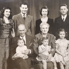 Far right first row along with sister, parents, grandparents, aunt, uncle, and cousin