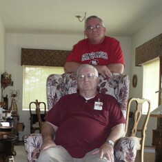 Eric standing, Larry sitting in chair he built.