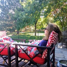 Late summer 2020. On her deck, called the Wallace Deck with Wallace flag and red and black lounging chairs.