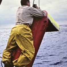 Larry - R/V Eastward - hanging G. Ewing 200 litre water bottle, 1968, Sargasso Sea (J P Thomas photo).  See "Science at Sea" story #15, Eastward.