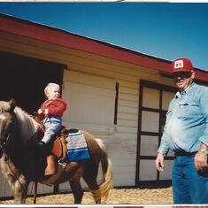 LeRoy helping grandson Joe ride