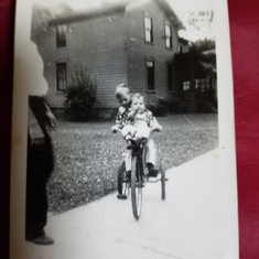 My mom with her older brother my Uncle Terry , he was giving her a ride on his bike.