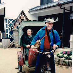 Loren driving a rickshaw with Lyn in tow at a cultural center park in Japan 1993