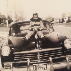 Dad as a little boy sitting on the hood of his parent's car. Oh how he always loved cars!