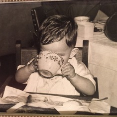 Dad/Lou as a baby eating in his highchair.