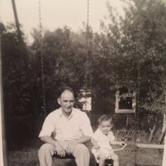 Dad/Lou as a little boy with his Father, Louie, swinging in their backyard.