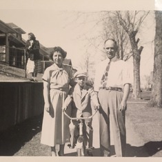 Lou as a Little boy riding his bike with his parents in their North Denver Neighborhood.