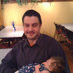 Heather's husband Justin holding Baby Issy. Nikky and Jeff's newborn baby.