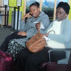 Dr (MRS) OMOTOWA at an airport, with one of her daughters-in-law