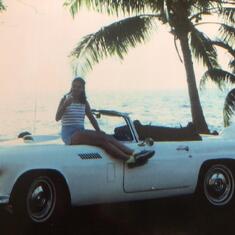Marie sipping champagne on the hood of a 1957 Thunderbird in HI.
