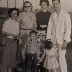 My parents with Mom's mother (Lucille) standing next to her, other relatives and me at about age 2. Dad was wearing his scrubs from the hospital where he was a surgical resident.