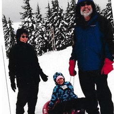 Izzyie loving snow sledding with her grandparents , Marjie and Rod