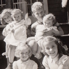 Sarah with her sisters and older brother Hugh on the steps at Milford in 1945
