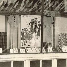 Mary (10 yrs) in shop window with dress she sewed 1939