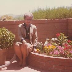 Mom showing off the corner flower bed on back patio in AZ May 1984