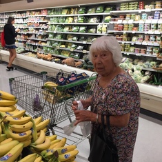 Mary grocery shopping for bananas