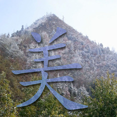 This is a Chinese character meaning beautiful. The mountains in the photo overlook her birthplace in China.