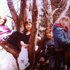 Michael (right, center) with his older sisters, Marta (left) and Michele (right) and cousin, Kelsey (left, center) in our grandparents big tree in their backyard.