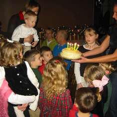 Michael is in the center.  You can see his delighted face as he awaits the birthday cake for Jesus with his cousins on Christmas Eve.