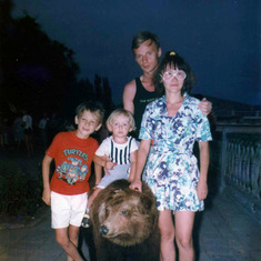 A very young Mike atop a bear, with brother Peter, father Vlad, and mother Olga.