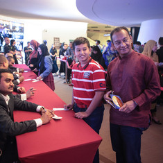 Ustadh Naim signing memorabilia for friends after a concert in Singapore