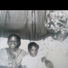 Oluwafolakemi, in the middle at about 2 years Old, seated between her mum and older brother, 'Dayo.