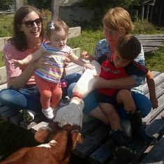 Patricia with Kym, Claire and Liam feeding Amos the calf at her family's farm.