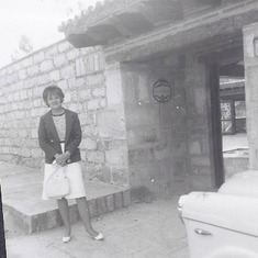 Pat in front of completed house 1964