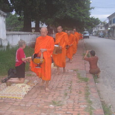 Giving rice to Buddhist monks.  Laos