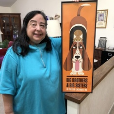 Anita holding a Charles Harper poster of Big Brothers of America