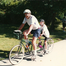 Grandpa and Cara on a bicycle built for two.