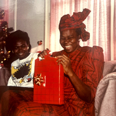 Mama opening Christmas gift with daughter, Uche