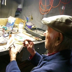 Painting a bird carving.