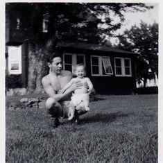 1954-Chrissy,a year old, on his knee in side yard.