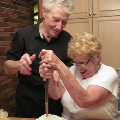 Mom and Dad trying to break into the top of their original wedding cake on their 50th wedding anniversary. It was well beyond the best before date.