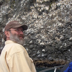 At a wall of puffins in Alaska with his "Bob's Chicken Ranch" favorite hat.