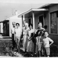 out in front of our first house, grandpa,my mom, my dad, my great grandma, my aunt, my grandma my cousin linda, me and my cousin randy